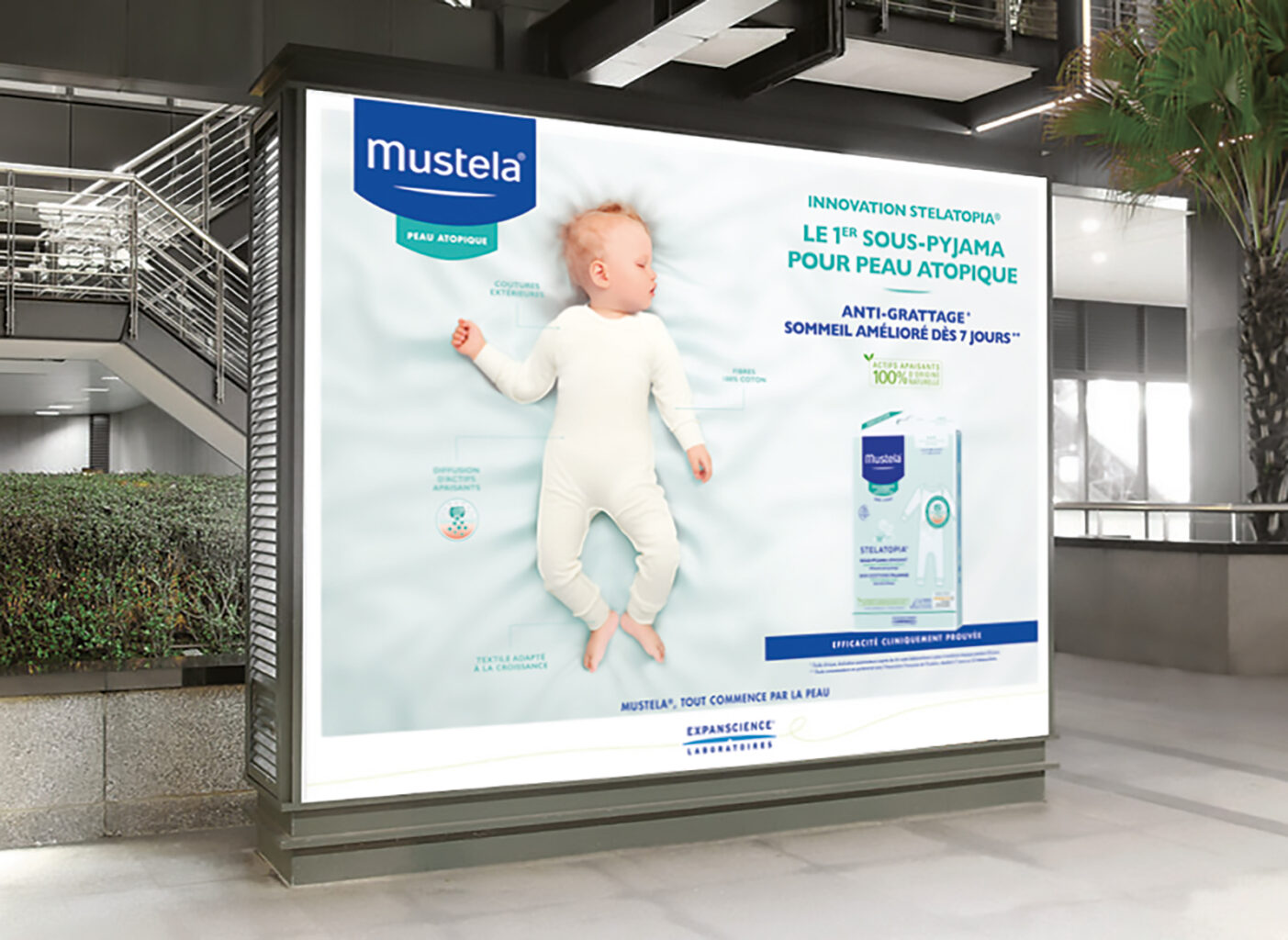 Affiche Mustela pour son sous-pyjama pour peau atopique dans un espace publique